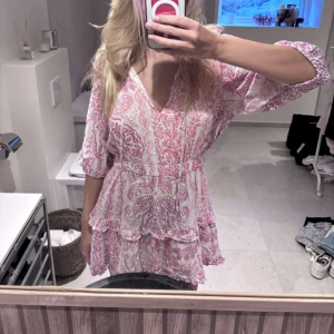 Rosa och vit kortklänning med volang och v-ringning - Säljer en söt kortklänning i rosa och vitt med blommigt mönster. Klänningen har v-ringning, volangdetaljer och trekvartsärmar. Perfekt för sommarens tillfällen!🌸☀️ storlek XL men passar s-XL skulle jag säga har vanligtvis M