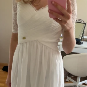 Vit klänning från Chiara Forthi - Gullig vit mini klänning från Chiara Forthi med spets på överdelen och trekvartsärm. Inga defekter, klänningen har dragkedja i ryggen och är perfekt för skolavslutning/student.💕