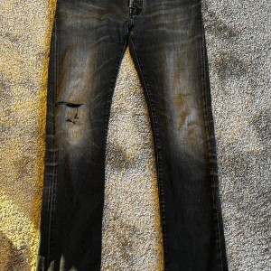 Svarta jeans från Jacob Cohën, style 688 - Säljer ett par svarta jeans från Jacob Cohën, style 688. Jeansen har en snygg tvätt med slitningar och en trasig detalj på vänster lår. Klassisk femficksmodell med broderad logga på myntfickan och knappar i midjan. Nypris: 5500kr, Säljes för 1250kr. Pris kan diskuteras vid snabb affär