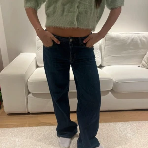 Mörkblå bootcut jeans - Säljer ett par mörkblå jeans med rak passform och klassiska fickor både fram och bak. Jeansen har normal passning och är tillverkade i ett klassiskt denimtyg. Perfekta för en avslappnad och trendig look.