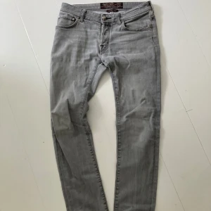 Grå jeans från Jacob Cohen - Snygga grå jeans från Jacob Cohen med klassisk femficksdesign och silverfärgade detaljer. Byxorna har normal passform och raka ben. Stilen är tidlös och passar perfekt till många olika outfits.