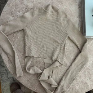 Beige ribbad topp  - Trendig beige ribbad topp med lång ärm och hög hals