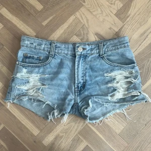 Ljusblå jeansshorts  - Säljer ett par blå jeansshorts med slitningar och fransar. Perfekta för sommaren! Skriv gärna vid frågor!💕