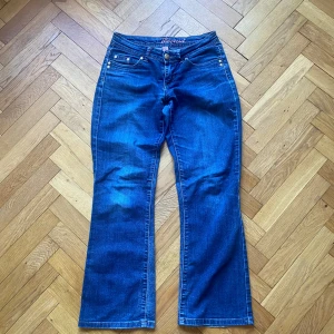 Lowwaist bootcut jeans  - Säljer ett par klassiska blå bootcut jeans från Denim Co. Jeansen har fem fickor, normal passform och snygga kontrastsömmar. Perfekta till vardags och lätta att matcha med olika toppar.