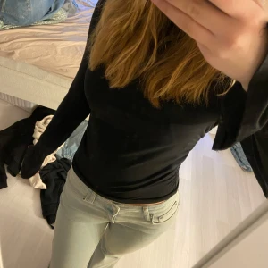 Svart polotröja från Gina Tricot - Säljer en svart, tight tröja från Gina Tricot. Tröjan har långa ärmar och är tillverkad i ett mjukt och stretchigt material som sitter snyggt mot kroppen.💕