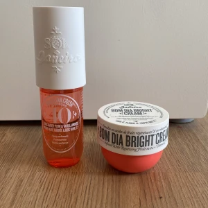 Sol de Janeiro Brazilian Crush och Bom Dia Bright Cream - Säljer ett set med Sol de Janeiro Brazilian Crush parfymmist och Bom Dia Bright Cream. Parfymmisten har en söt doft av plommon och vanilj, och kommer i en orange plastflaska med vit kork. Kroppskrämen är i en rund burk med vit lock och korallrosa botten.