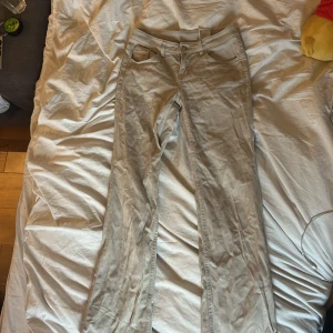 Beige byxor från Divided - Säljer ett par beige byxor från H&M i storlek 36. Byxorna har raka ben, klassisk femficksdesign och stängs med dragkedja och knapp. Perfekta till vardags för en clean och enkel stil.
