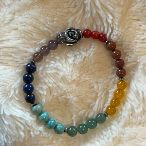 kristall armband  -  armband med äkta kristaller i regnbågens färger och en silverfärgad ros som detalj. Är kristaller för alla chackran. 