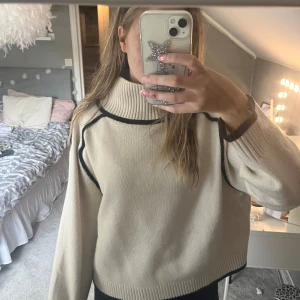 Beige stickad tröja med svarta detaljer - Snygg ljusbeige stickad tröja med svarta sömmar och polokrage från H&M i storlek L💕💕