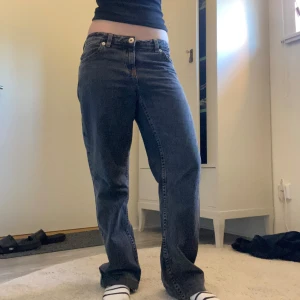 Mörkgrå straight/ baggy jeans - Säljer ett par mörkgrå jeans med straight/ baggy passform som har orange/bruna sömmar längst fickor o.s.v. Jeansen har normalhög midja och stängs med dragkedja och knapp. Jag har sytt upp dem ca 6 cm om man skulle vilja sprätta upp det och få dem längre. Jag är ca 168cm lång. Måttet rakt över midjan är 39,5. Innerbenslängden är ca 62cm men dom har ju också lite ”häng”. Skriv för fler bilder eller frågor!🫶