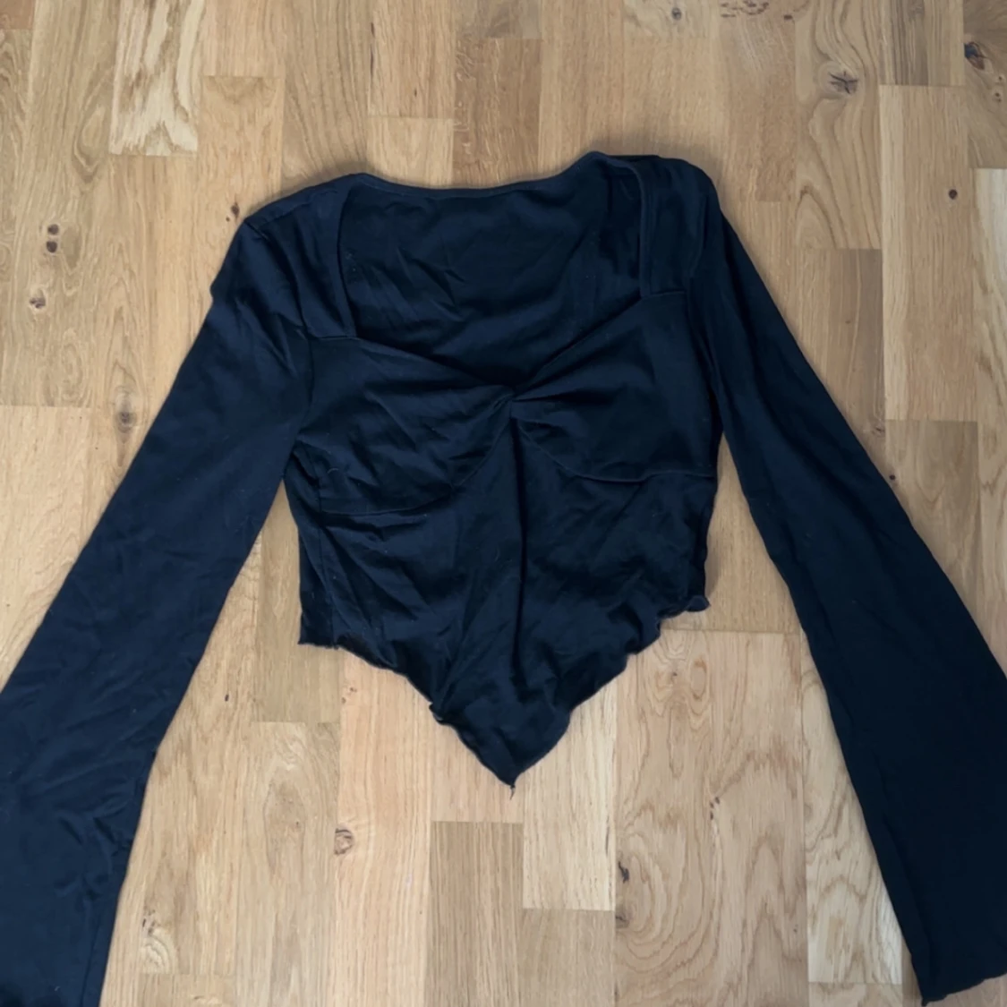 Svart långärmad topp med asymmetrisk nederkant