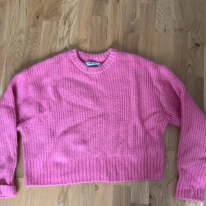 Rosa stickad croppad tröja - Säljer en söt rosa stickad tröja. Tröjan är croppad med rund halsringning och långa ärmar. Storlek M