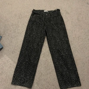 Svarta leopardmönstrade jeans från Pull&Bear - Säljer ett par svarta jeans med leopardmönster från Pull&Bear. Byxorna har raka ben, normal passform. Aldrig använda🔥