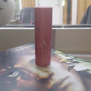 Läppstift i nude från Makeup Mekka - Säljer ett nude-färgat läppstift från Makeup Mekka. Hylsan är rosa och stilren, och läppstiftet har en krämig formula som ger en naturlig look. Perfekt för dig som gillar en mjuk och diskret färg på läpparna.