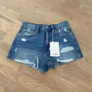 Jeansshorts från Pull&Bear - Blå jeansshorts från Pull&Bear med slitna detaljer. Normal i storleken. 