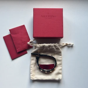 Valentino Garavani svart armband med nitar - Tjena! Säljer ett skitsnyggt svart armband från Valentino Garavani med guldiga nitar. Levereras med två extra nitar och dustbag. Skick 7/10 Inga defekter och det är bara höra av sig vid minsta lilla fundering 🙌