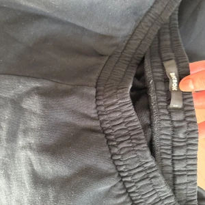 Svarta mjukisbyxor från Bik Bok - Svarta lowwaist mjukisbyxor från Bik Bok med resår i midjan och raka, lite vidare ben. Perfekta för en avslappnad stil och superbekväma att ha på sig. Passar dig som gillar en enkel och stilren look.