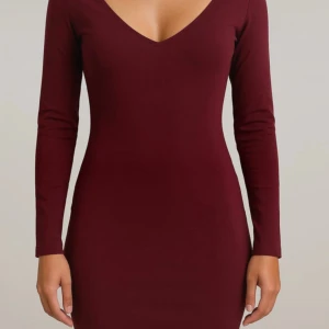 Vinröd långärmad klänning från Stay - Vinröd, figurnära klänning från Stay med lång ärm och v-ringning. Klänningen har en enkel, stilren design och är tillverkad i ett stretchigt material som sitter snyggt på kroppen. Perfekt för dig som gillar minimalistisk stil.