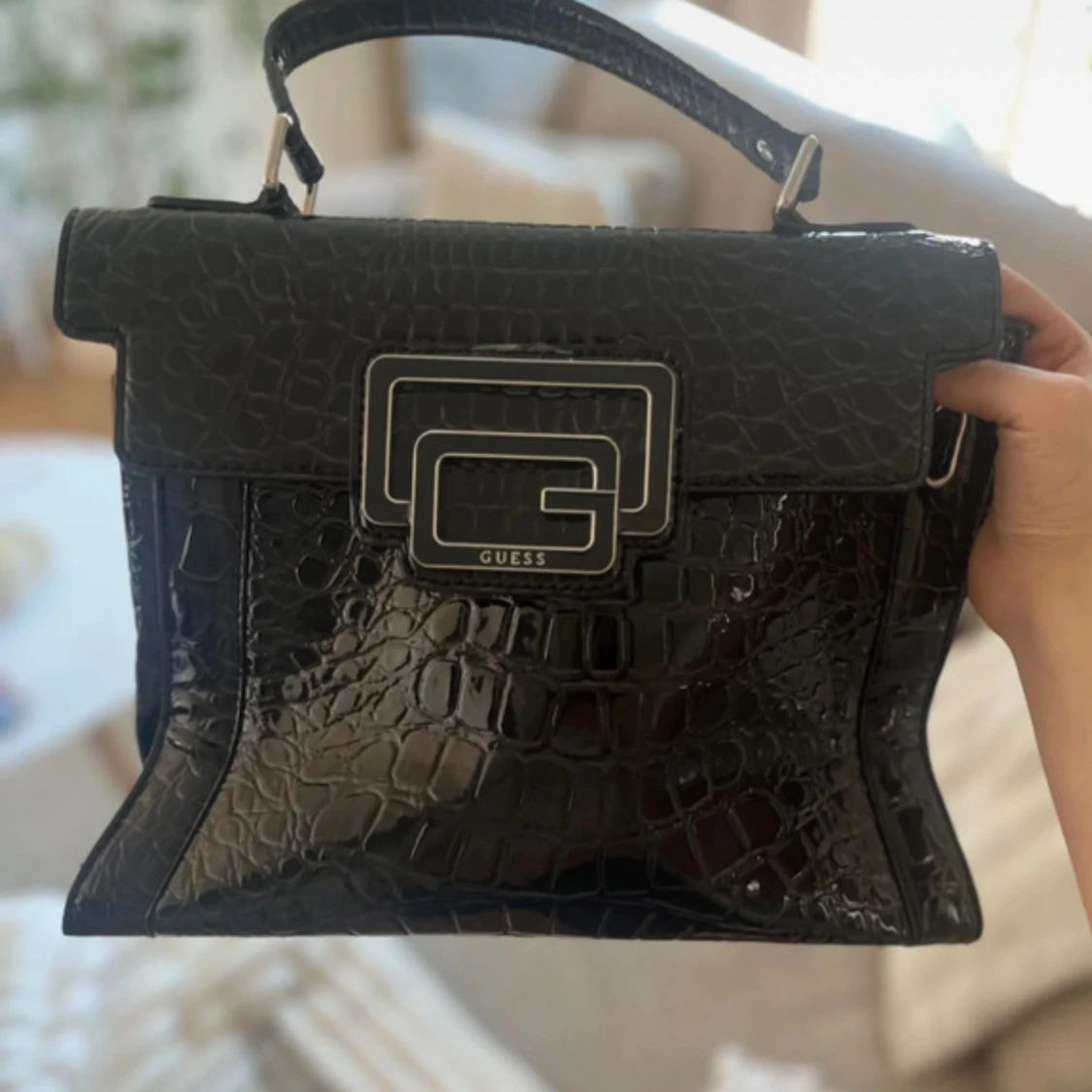 Svart handväska i krokopräglad syntet från Guess