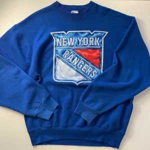 Vintage NHL New York Rangers sweatshirt - Vintage sweatshirt från Pro Player med stort New York Rangers-tryck på bröstet. Tröjan har rund halsringning och långa ärmar. 
