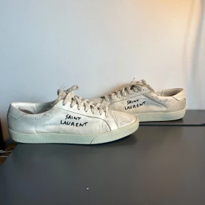  Saint Laurent skor - Säljer ett par vita sneakers från Saint Laurent i väldigt fint skick kvitto finns och det är bara att höra av sig om det är något man funderar över 