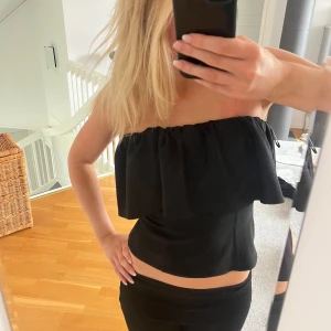 Svart bandau topp - Säljer en svart bandautopp med volangdetalj upptill från Zara. Toppen har ingen dragkedja men är stretchig upptill! Endast använd 1 gång och är så gott som ny. storlek  S. Jag är 175 cm som referens. 💗💗💗