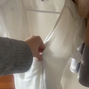 Vit omlottklänning med kort ärm - Säljer en söt vit omlottklänning med knyt i midjan och v-ringning. Klänningen har korta ärmar och är tillverkad i ett lätt, flowy material som passar perfekt till varma dagar! Använd en gång till skolavslutning 🥰