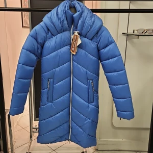 Blå mellan lång pufferjacka från Alpine Pro - Säljer en mellan lång, blå pufferjacka från Alpine Pro i storlek XS. Jackan har inte huva, men större krage, dragkedja framtill och två fickor med dragkedja. Perfekt för kyliga dagar och riktigt snygg färg som sticker ut. FINNS ÄVEN I M storleken!