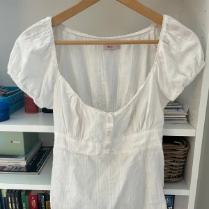 Vit kort blus med puffärm från Nelly - Superfin vit blus från Nelly med puffiga kortärmar och knappar på framsidan💗 jag har använt den 2 gånger och trivs inte därför säljer jag! Hör av om du har någon fundering💕