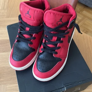 Air jordan 1 Mid röda / svarta  - Säljer mina Jordan 1’s i rött/svart och vitt. Har haft på mig de kanske 3 gånger, annars har de stått i förrådet. Bra skick förutom lite damm, säljer pga för tajta på mig.