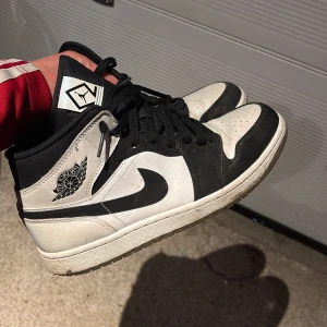 Nike Air Jordans svartvita sneakers - Säljer ett par klassiska Nike Air Jordans i svart och vitt. Skorna har svart snörning, rund tå och platt sula. Ikonisk vinge-logga på sidan och perforerad tåbox för extra ventilation. Perfekta för dig som gillar streetwear och vill sticka ut. Nytt pris 3000 kr mycket rare. Dimond Jordan 1