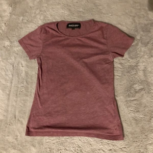 Rosa t-shirt från Take Off - En enkel och stilren rosa t-shirt från Take Off. T-shirten har rund halsringning och korta ärmar. Perfekt basplagg att matcha med jeans eller shorts. Mjuk och bekväm bomullskänsla.