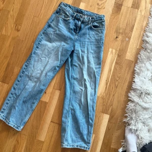 Blå raka jeans från Collusion - Säljer ett par ljusblå jeans från Collusion med raka ben och klassisk femficksdesign. Jeansen har hög midja och är i en skön denimkvalitet. Perfekta för en avslappnad och trendig look. Jag är 164 cm lång och de går till ankeln på mig 