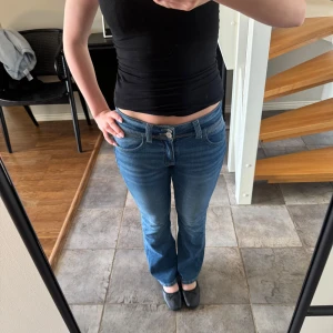 Blå bootcut jeans - Säljer ett par blå jeans med bootcut passform och normal midja. fina detaljer på bakfickorna. Perfekta till vardags och lätta att matcha med olika toppar. använda 2-3 gånger, storlek 152 gina tricot young 