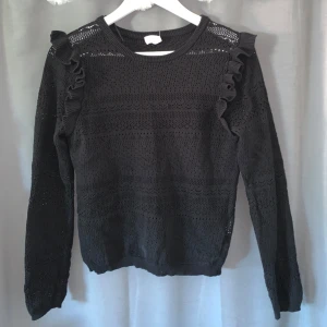 Svart stickad tröja  - Svart stickad tröja med lite volanger vid axlarna, super gullig och passar till många tillfällen💕