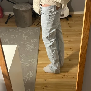 Ljusblå bootcut jeans - Säljer ett par ljusblå jeans med bootcut passform och stora bakfickor. Jeansen har låg midja och är tillverkade i klassiskt denimtyg. 