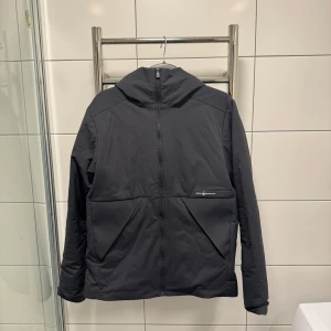 Sail Racing Race Primaloft Hood - Säljer en svart jacka från Sail Racing med huva och dragkedja. Skulle säga att jackan sitter mer som storlek S. Nypris 3000