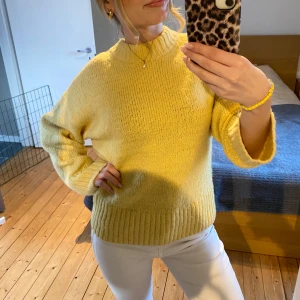 Gul stickad tröja - Säljer en mysig gul stickad tröja med ribbade detaljer vid hals, ärmslut och nederkant. Perfekt för kyligare dagar och ger en härlig färgklick till garderoben. Passar bra till både jeans och kjol. 🌼 Använd ett fåtal gånger så tröjan är i god skick!!! 