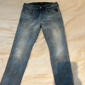 Blå jeans från Replay - Snygga blå jeans från Replay med en lätt tvättad look. Märket Replay syns på en läderpatch bak och på en liten etikett vid fickan fram.