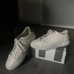 Vita sneakers från Pull&Bear - Säljer ett par stilrena vita sneakers från Pull&Bear. Skorna har en klassisk design med snörning och rund tå. Perfekta för en avslappnad look eller en fin kväll på stan. Köpta på zalando för 599kr för snart ett år sedan. Skorna är använda en gång ( på skolavslutningen i 9an ). Mycket fint skick, bara några få smutsfläckar på övre sula som inte bör vara några problem att få väck. 