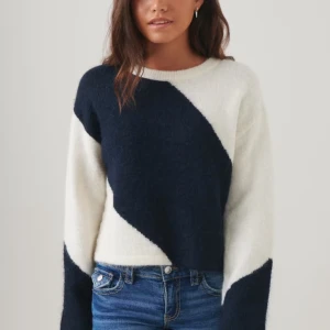 Mörkblå och vit tröja från Gina. - Snygg stickad  tröja i mörkblått och vitt med ett diagonalt mönster. Tröjan har långa ärmar och en mjuk, mysig känsla. Perfekt för en stilren look. Slutsåld i storlek 170.