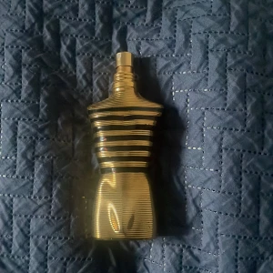 Jean Paul Gaultier Le Male Elixir Parfym pris kan diskuteras ca 30-45 ML kvar - Ca 30-45 ML kvar. Säljer en elegant parfymflaska som luktar manlig vanilj med lite honung från Jean Paul Gaultier, Le Male Elixir. Flaskan har en unik design i form av en manlig torso med guld- och svartfärgade ränder. Kommer med en matchande metallförpackning som ger en lyxig känsla. Perfekt för den som vill ha en distinkt och stilren doft.