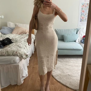 vit stickad sommarklänning💐💐 - Snygg beige stickad klänning med en figurnära passform. Klänningen är ärmlös och har en elegant, enkel design som passar perfekt för varmare dagar och festkvällar. Den har en fin struktur och är knälång med slits på sidan💞säljer endast för har så många vita klänningar, men har älskat denna och hoppas kan ge den nytt liv hos någon annan🩷🩷