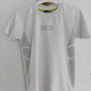 Vit kortärmad t-shirt med mönster - Säljer en vit kortärmad t-shirt från XTS med ett coolt perforerat mönster både fram och bak. Perfekt för träning eller en aktiv dag. Materialet är lätt och andas bra. 