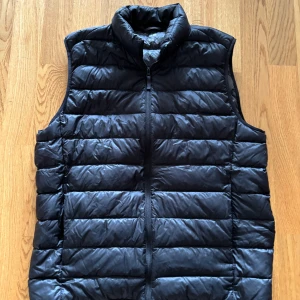 Svart dunväst från Uniqlo - Säljer en nuförtiden sällsynt svart dunväst från Uniqlo i storlek M som tyvärr har blivit för liten för mig. Den är i princip i nyskick och har inga defekter! Riktigt schysst under våren och sommarn! Skicka pm om de finns några frågor✌🏻