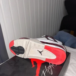 Nike Air Jordan 4 Retro  - Säljer ett par Nike Air Jordan 4 Retro i färg vitt, svart och röd. Perfekta för sneakerheads som vill ha en klassisk stil. Hör av er om ni har frågor!