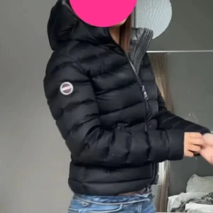 Svart dunjacka från Colmar - Säljer en skit snygg svart dunjacka från Colmar. Jackan har en huva och stängs med dragkedja. Den har två fickor med dragkedjor framtill. Den är i jätte bra skick. Perfekt för våren💖