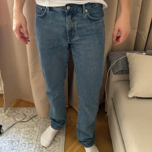 Blå jeansbyxor - Säljer ett par klassiska blå jeansbyxor med normal passform ifrån East west. De har en midwaist design och är tillverkade i jeansmaterial. Perfekta för en avslappnad stil. Storlek 32/32