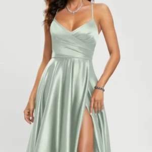 Ljusgrön balklänning med slits - Elegant ljusgrön långklänning i satin med smala axelband.Klänningen har en v-ringad urringning och en stilfull slits framtill, perfekt för en festlig kväll. Den är i storlek 36 men passar mig som vanligtvis är 34