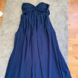 Marinblå strapless balklänning  - Elegant marinblå axelbandslös balklänning. Har används en gång och är i jättefint skick. Har inbyggd bh och en silikonremsa som håller klänningen plats även om man hoppar och dansar😊 